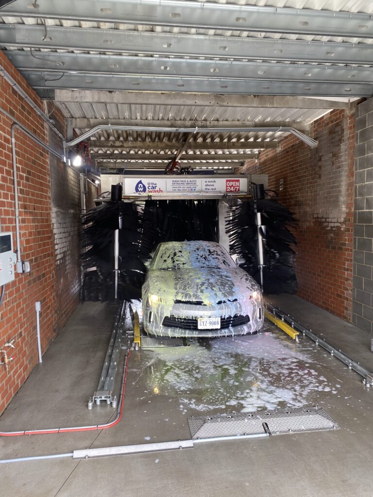 Car covered in foam soap in the high-pressure automatic wash bay at @ The Car Wash in Fredericksburg, VA
