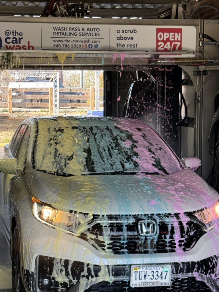 Car covered in colorful tri-color foam soap during a wash at @ The Car Wash in Fredericksburg, VA